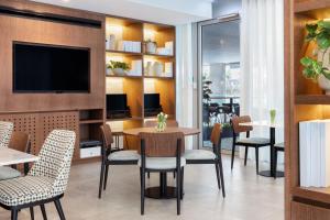 a restaurant with tables and chairs and a flat screen tv at Four Points by Sheraton Matosinhos in Matosinhos