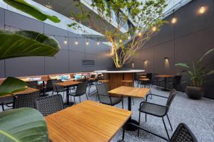 a restaurant with wooden tables and chairs and plants at Four Points by Sheraton Matosinhos in Matosinhos