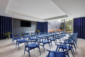 a room with blue chairs and tables and a screen at Four Points by Sheraton Matosinhos in Matosinhos