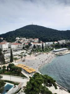 Cosmo apartment في دوبروفنيك: شاطئ عليه مظلات صفراء وناس