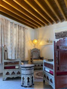 een woonkamer met stoelen en een tafel en gordijnen bij Bab al-sham funduk in Akko