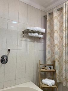 a bathroom with a shower and a toilet and towels at Bab al-sham funduk in ‘Akko