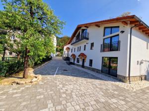 a cobblestone driveway in front of a white building at RA House in Braşov