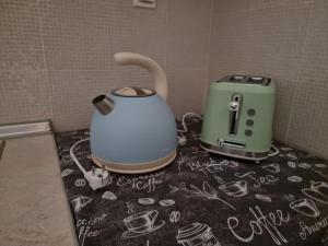 a table with a toaster and a tea kettle on it at Sunny House in Perea