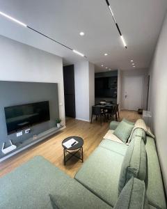 a living room with a couch and a tv at NEW Brilant Apartment in Tirana