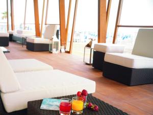 a living room with white couches and drinks on a table at TERESITA WELLNESS CLUB in Viareggio