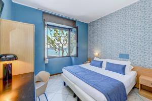 una camera blu con un letto e una finestra di Hotel Aurora a Desenzano del Garda