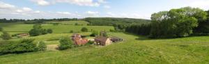 une vue aérienne sur une maison dans un champ verdoyant dans l'établissement Orchard Barn, à Little Dean