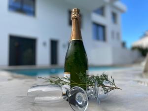 Una botella de champán sentada en una mesa. en Calpe villa lujo playa piscina jardin barbacoa ideal familias y grupos, en Calpe