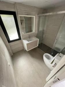 a bathroom with a toilet and a sink and a mirror at Calpe villa lujo playa piscina jardin barbacoa ideal familias y grupos in Calpe