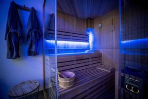 uma casa de banho com uma banheira de madeira com iluminação azul em Wood 47 spa em Précy-sur-Oise