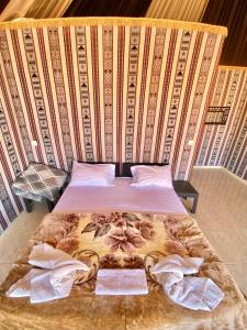 a bed with two towels on it in a room at Rum Nights Bedouin Camp in Wadi Rum