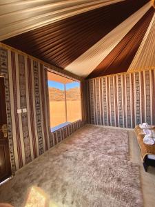 an empty room with a bed and a window at Rum Nights Bedouin Camp in Wadi Rum