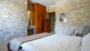 a bedroom with a white bed in a brick wall at Arya Suits in Antalya