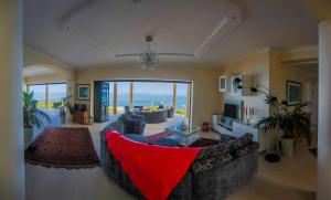 a living room with a large couch and a view of the ocean at La Vue in Beau Vallon