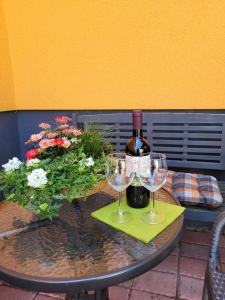 a table with a bottle of wine and two glasses at Ferienhaus Jäger in Mörlenbach