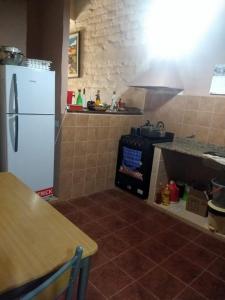 cocina con nevera blanca y fogones en Casa de Sumaj pacha en Tilcara