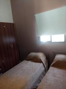 a small bedroom with two beds and a window at La calandria in Tilcara +7 photos