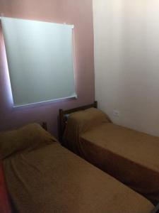 una habitación con dos camas y una ventana en La calandria, en Tilcara