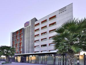 a large building with palm trees and palm trees at Best Western Parco Paglia Hotel in Chieti