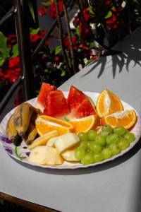 un plato de frutas y uvas en una mesa en Abu Homestay, en Kohīma