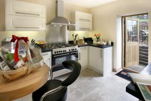 a kitchen with white cabinets and a stove at Stables in Little Dean