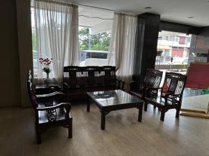 a living room with furniture and a table and chairs at De Choice Hotel Tawau in Tawau