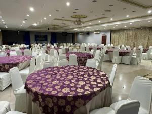 a banquet hall with purple and white tables and chairs at De Choice Hotel Tawau in Tawau