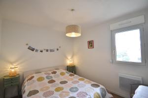 a bedroom with a bed and a window at Point d'or H - Joli appartement rénové au bord de l'océan in Soorts-Hossegor