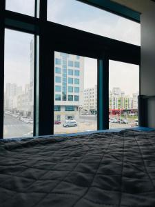 a bedroom with a bed and a view of a city at Paradiso Backpackers Nest 1 in Abu Dhabi