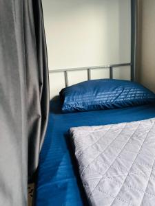 a bed with blue sheets and a blue pillow at Paradiso Backpackers Nest 1 in Abu Dhabi