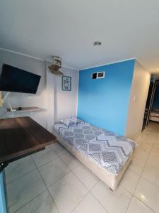 a room with a bed and a television and a table at Apartamentos Vistas del Caribe in Cartagena de Indias