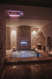 オストゥーニにあるBorgo Montetortoの建物内のプール付きの大きな石造りの部屋