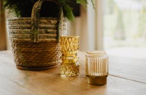 two gold candles and a basket on a wooden table at Bungalow Rondomzon in Putten