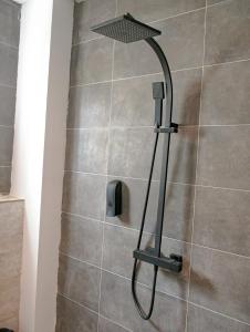 a shower with a shower head in a bathroom at VOAK Home in Douala