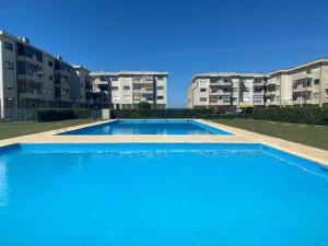 a large swimming pool in front of some apartment buildings at Beachfront Apartment With Sea View in Azurara