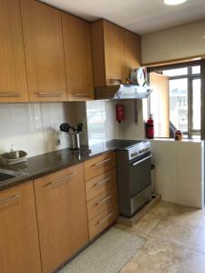 uma cozinha com armários de madeira e um forno com placa de fogão em Beachfront Apartment With Sea View em Azurara