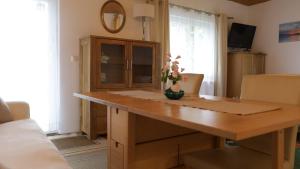 a wooden desk in a living room with a table at Ferienwohnung Schwanensee in Lenzing