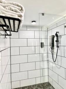 a bathroom with a shower with white tiled walls at Le Bijou Chic in the Heart of Saigon Charm with VIEW in Ho Chi Minh City +62 photos