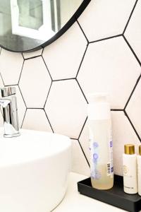 uma casa de banho com azulejos hexagonais brancos na parede em Dreambed 1 em Baia Mare