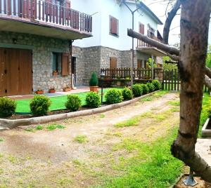 a house with a fence and a yard with plants at Casa Palmieri bilocale Indipendente con Giardino Privato Relax sul Monte Amiata in Castel del Piano