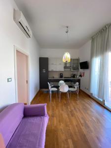 a living room with a purple couch and a table at Sunny loft with terrace and Jacuzzi in the city centre in Palermo
