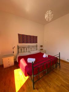 a bedroom with a bed with red sheets and a chandelier at Sunny loft with terrace and Jacuzzi in the city centre in Palermo