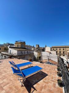a patio with a blue table and chairs on a roof at Sunny loft with terrace and Jacuzzi in the city centre in Palermo
