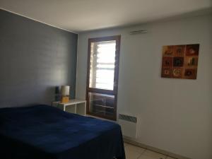 a bedroom with a blue bed and a window at Le Village in Marseille