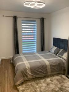 a bedroom with a bed with a large window at Brand New Vintage 2 Bed Flat No Parties No Events in West Thurrock