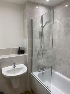 a bathroom with a shower and a sink and a bath tub at Brand New Vintage 2 Bed Flat No Parties No Events in West Thurrock