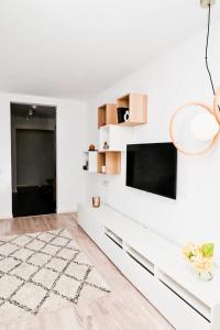 uma sala de estar branca com uma televisão de ecrã plano numa parede branca em Dreambed 1 em Baia Mare