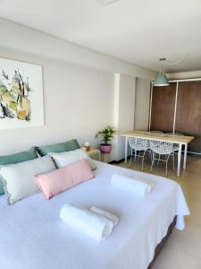 1 dormitorio con 1 cama grande con almohadas rosas y blancas en CDM Temporal 2 en Rosario