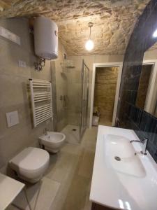 a bathroom with a toilet and a sink and a shower at Suite Duomo Trani 6 in Trani